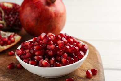 Photo of Ripe juicy pomegranate grains on white table, closeup