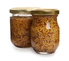 Photo of Jars of whole grain mustard on white background