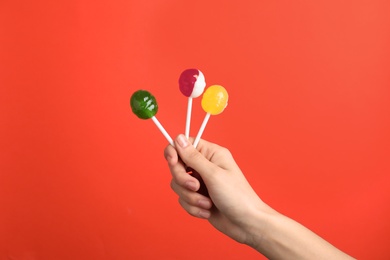 Photo of Woman holding yummy candies on color background