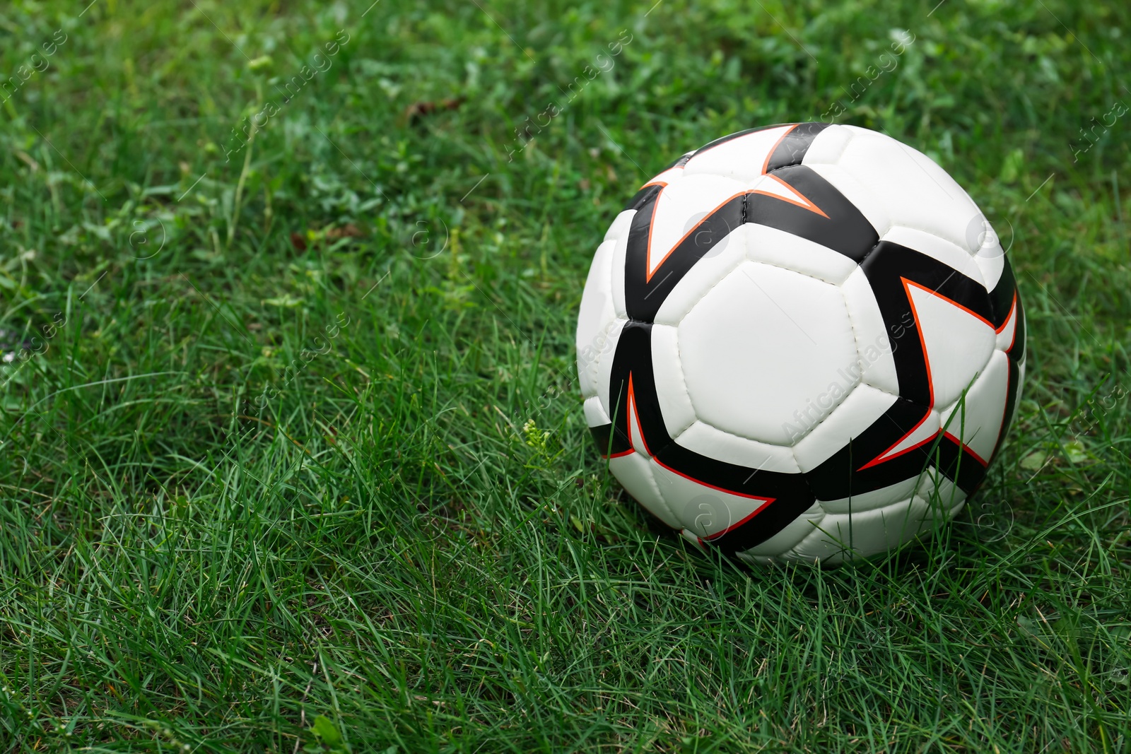 Photo of New soccer ball on fresh green grass outdoors, space for text