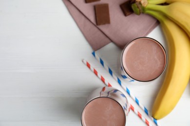 Photo of Yummy chocolate milk on white wooden table, flat lay. Space for text