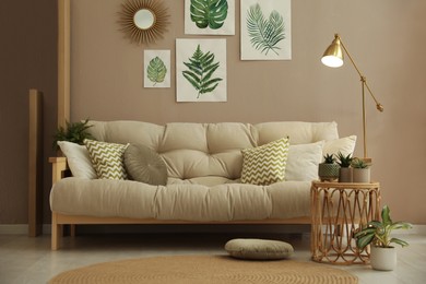 Stylish living room interior with comfortable sofa and beautiful pictures on wall