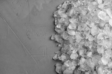 Heap of crushed ice on grey table, top view. Space for text