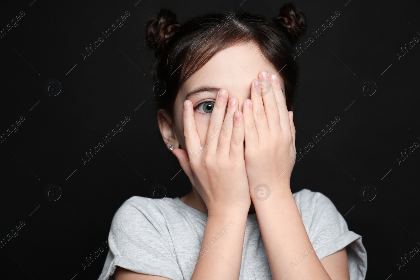 Photo of Little girl feeling fear on black background