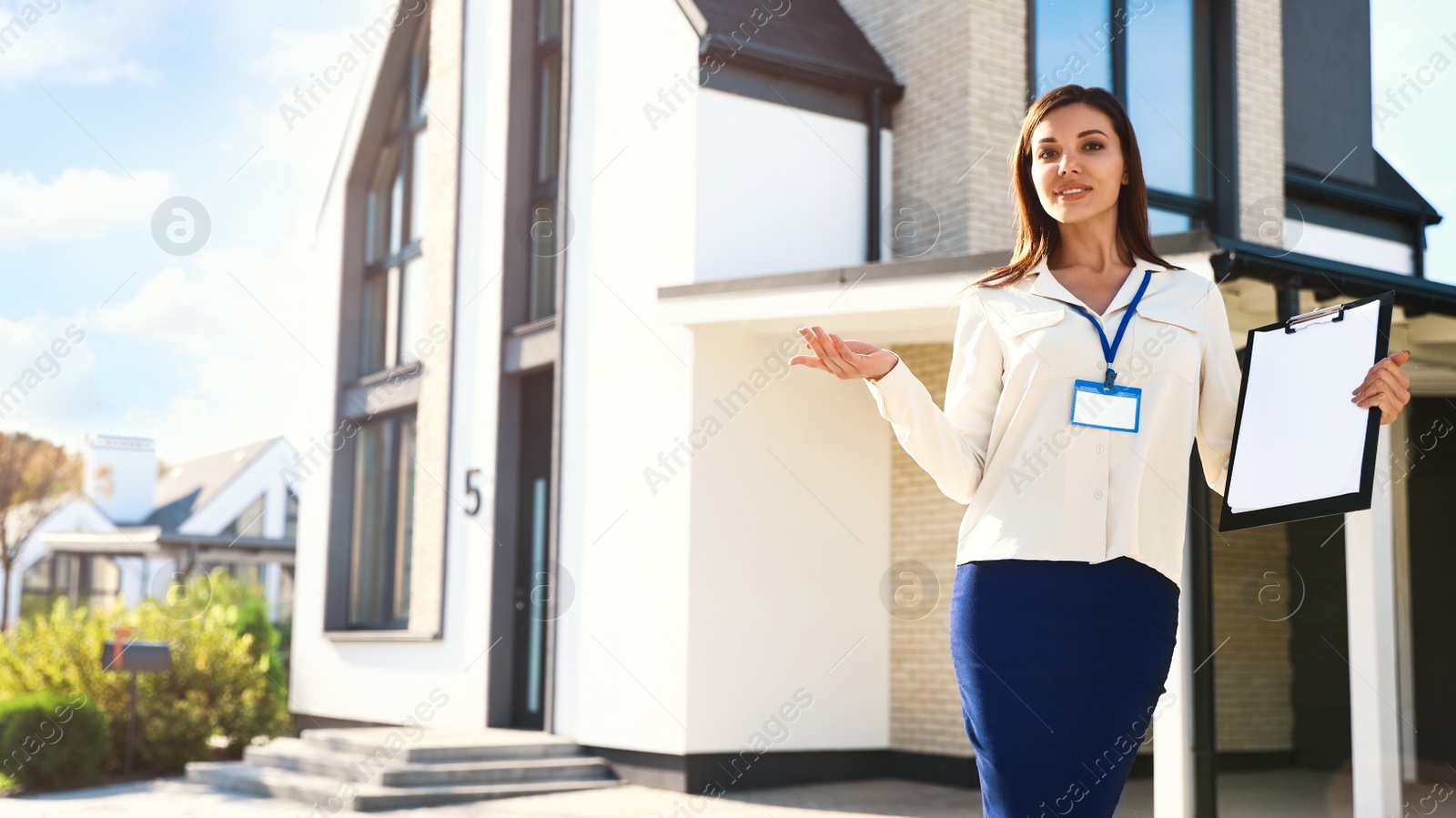 Photo of Real estate agent showing house for sale outdoors