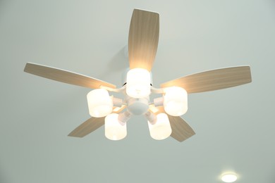 Ceiling fan with lamps indoors, low angle view