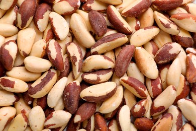 Photo of Many delicious Brazil nuts as background, top view