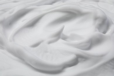 Photo of Texture of white shaving foam as background, closeup