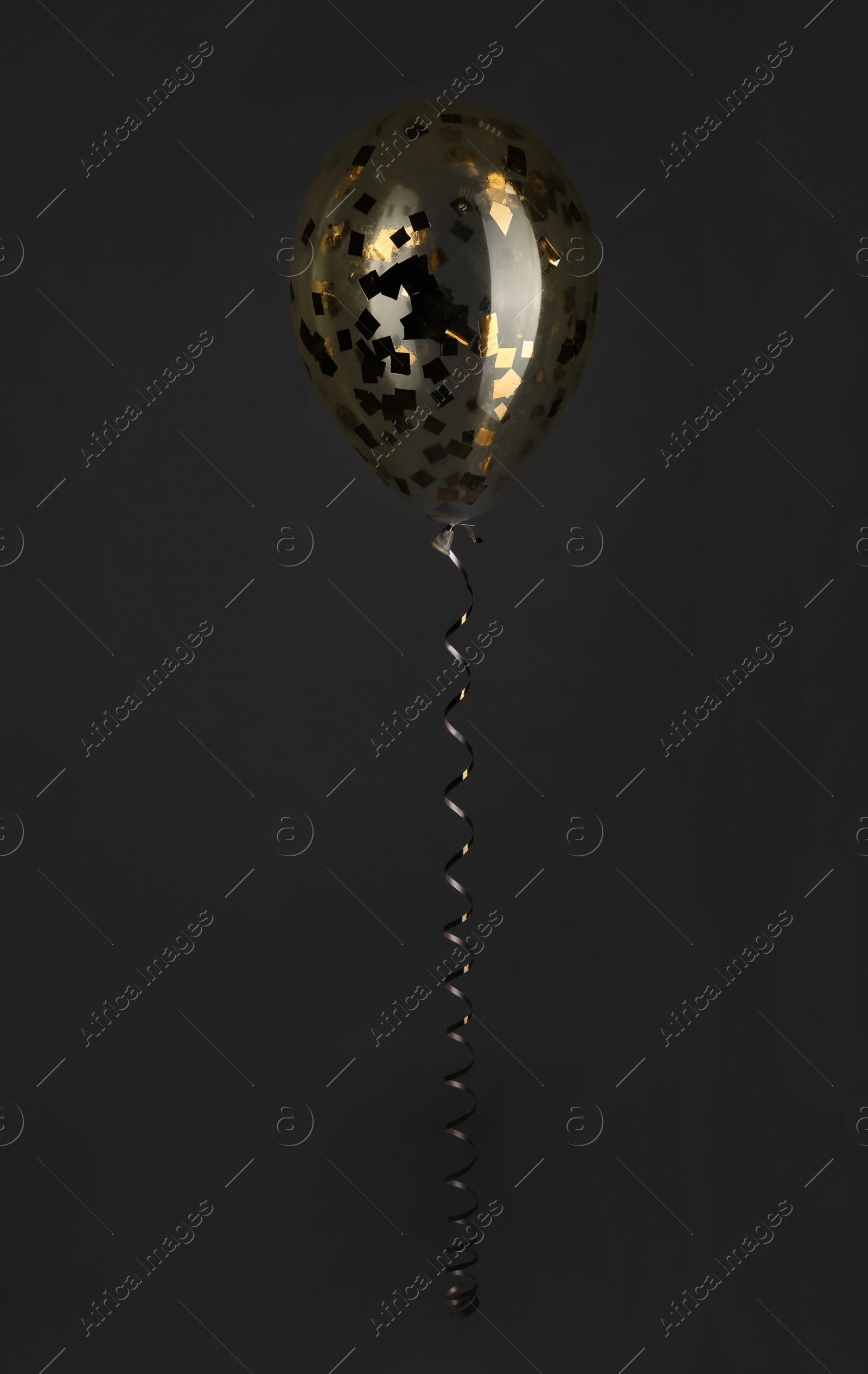 Photo of Bright balloon with sparkles on dark background