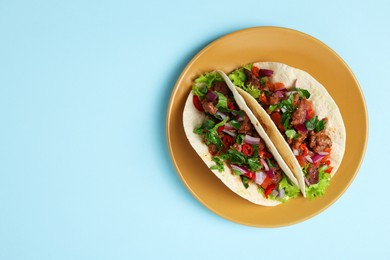 Photo of Delicious tacos with meat and vegetables on table, top view. Space for text