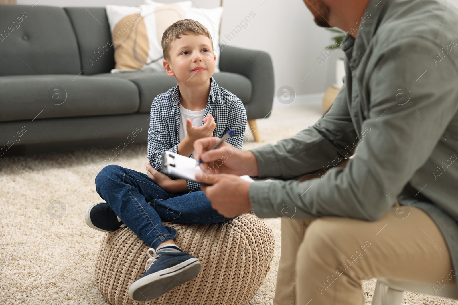 Photo of Dyslexia treatment. Speech therapist working with boy in room