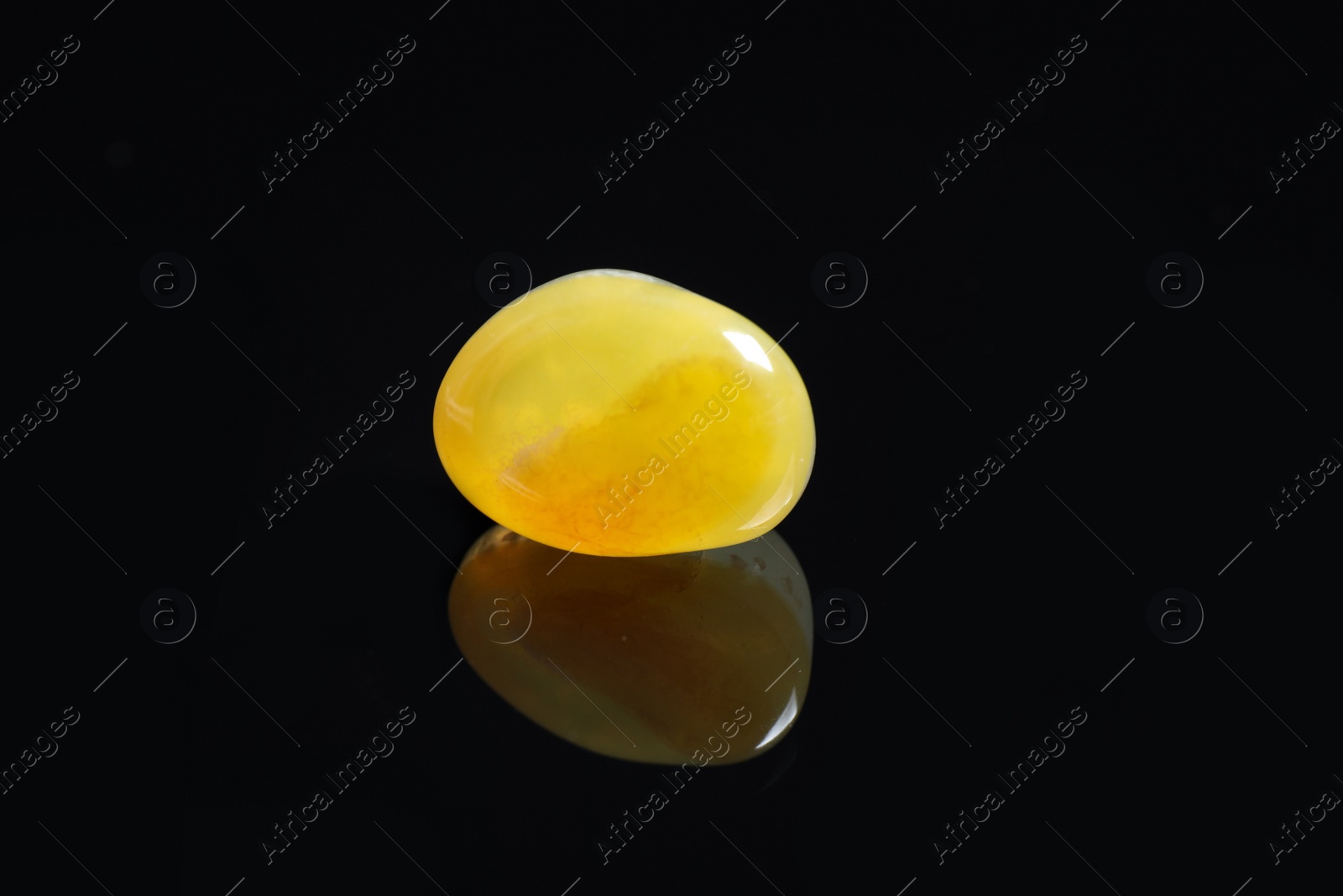 Photo of Beautiful honey agate gemstone on black background