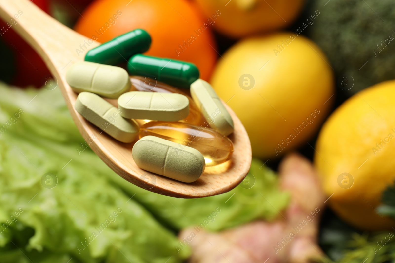 Photo of Dietary supplements. Spoon with different pills over food products, closeup