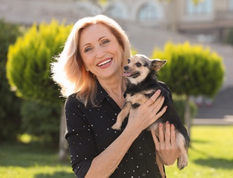 Beautiful mature woman with cute dog in park