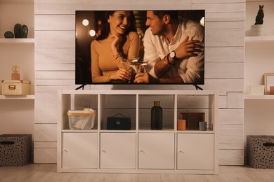 Image of Scene of romantic movie on TV in room