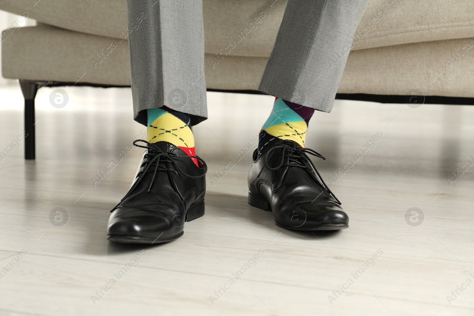 Photo of Man wearing stylish shoes and colorful socks indoors, closeup