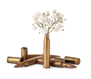 Bullets and cartridge cases with beautiful gypsophila flowers isolated on white