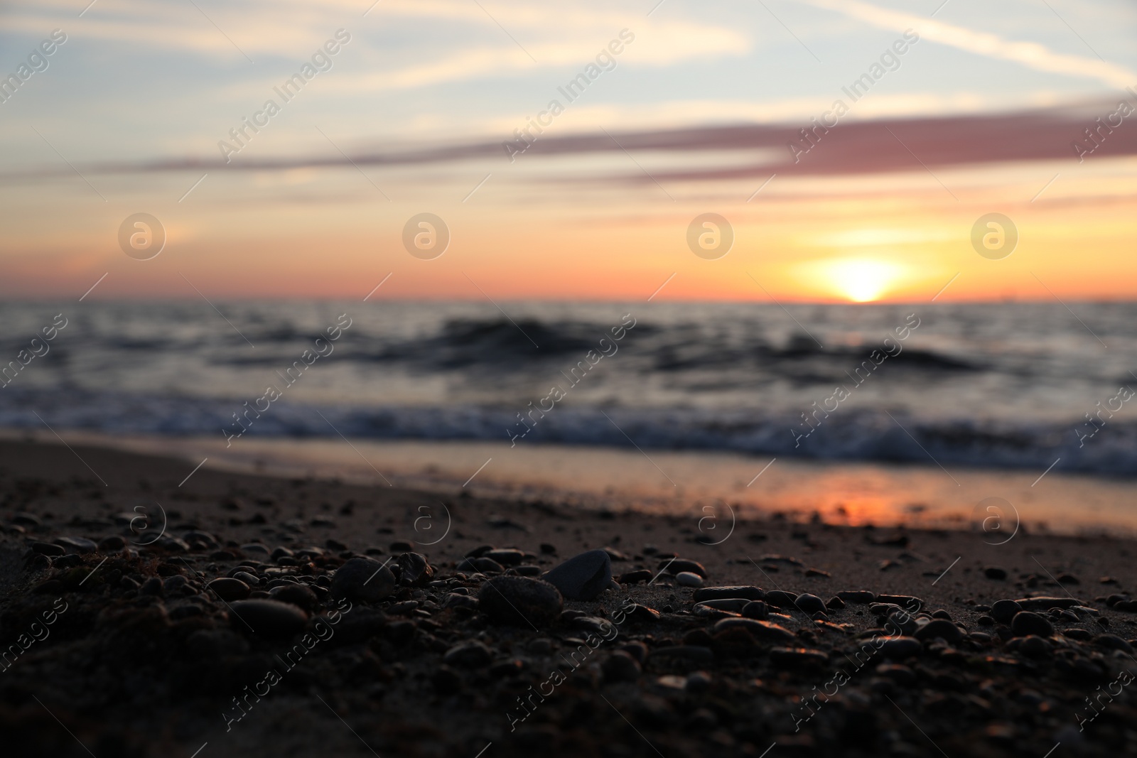 Photo of Tropical beach with sand and stones near sea at sunset, selective focus. Space for text