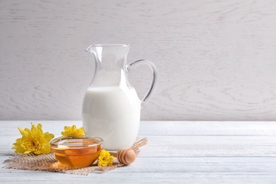 Beautiful composition with milk and honey on wooden table