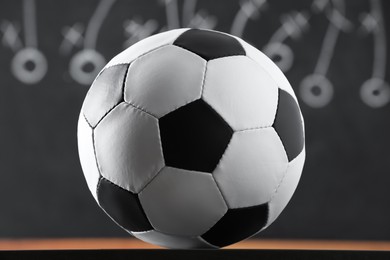 Photo of Football ball against blurred game scheme, closeup