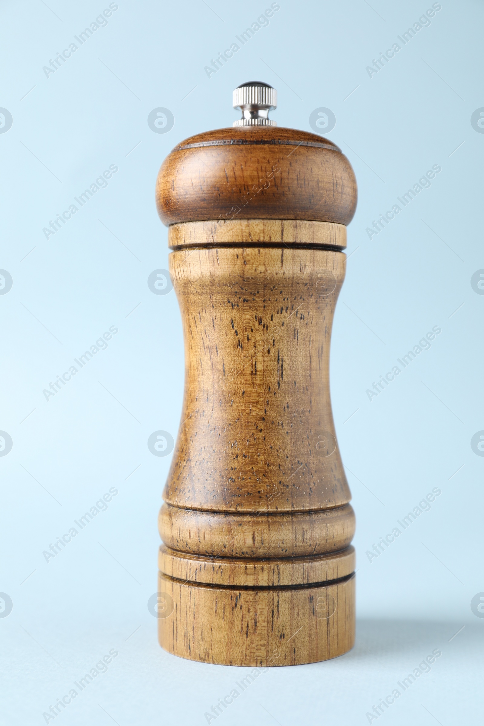Photo of One wooden shaker on light background, closeup