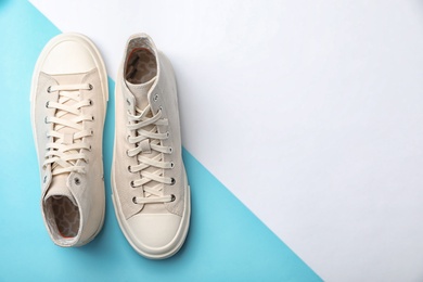 Pair of sneakers on color background, top view