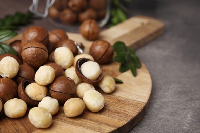 Photo of Tasty organic Macadamia nuts on grey table, closeup. Space for text