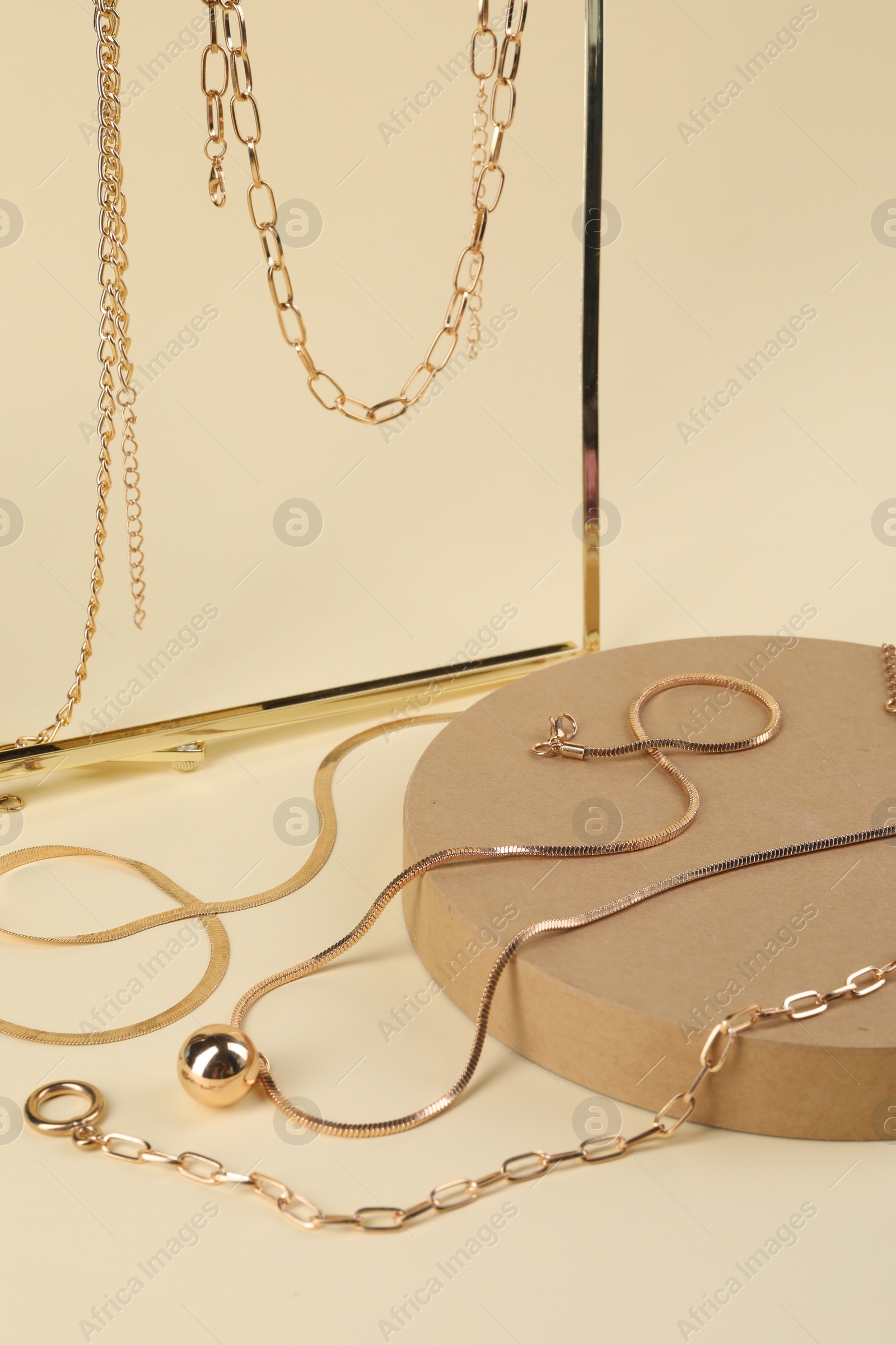 Photo of Presentation of different metal chains on beige background. Luxury jewelry