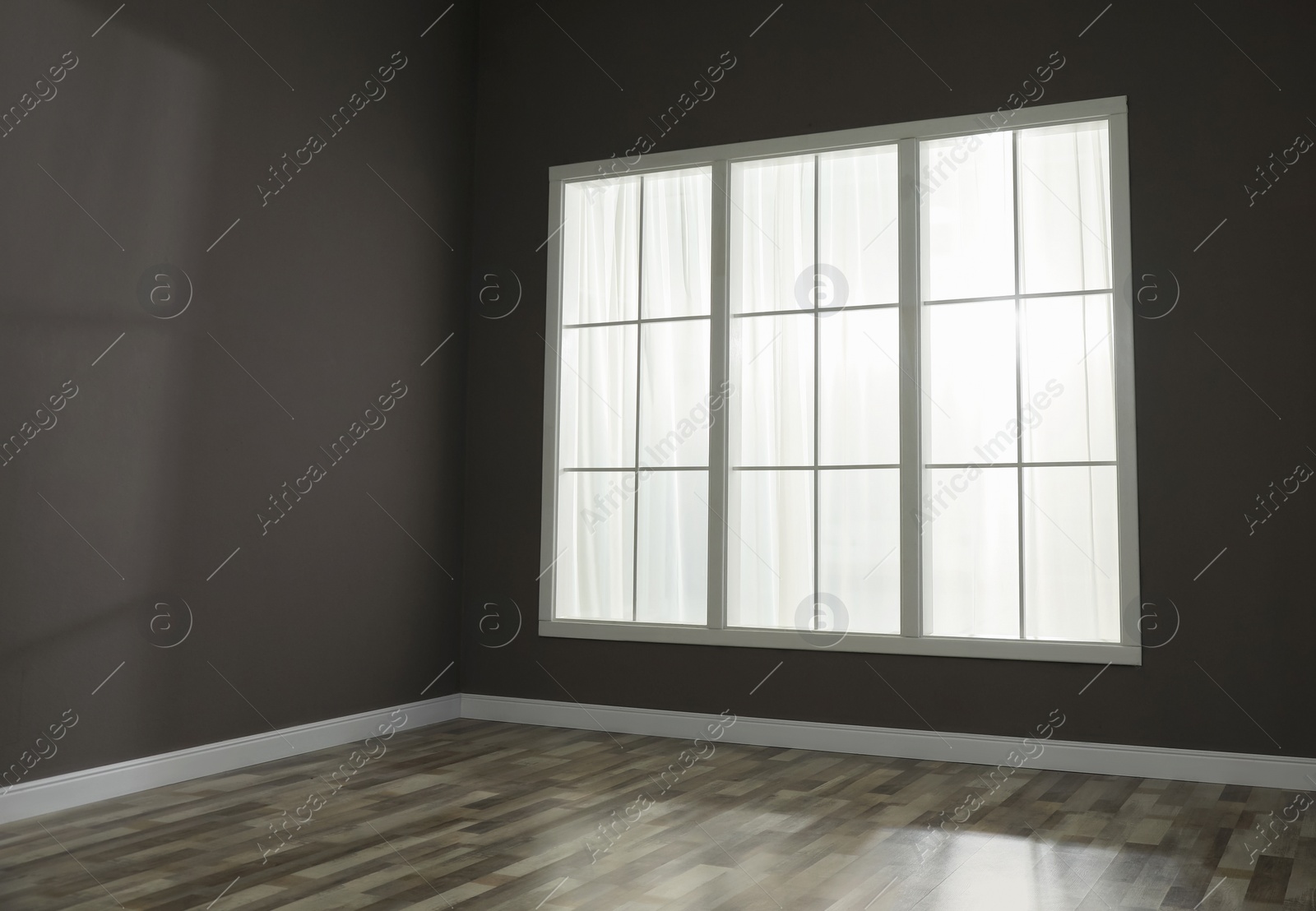 Photo of Empty room with brown walls and large window