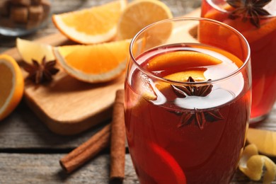 Photo of Aromatic punch drink and ingredients on wooden table, closeup. Space for text