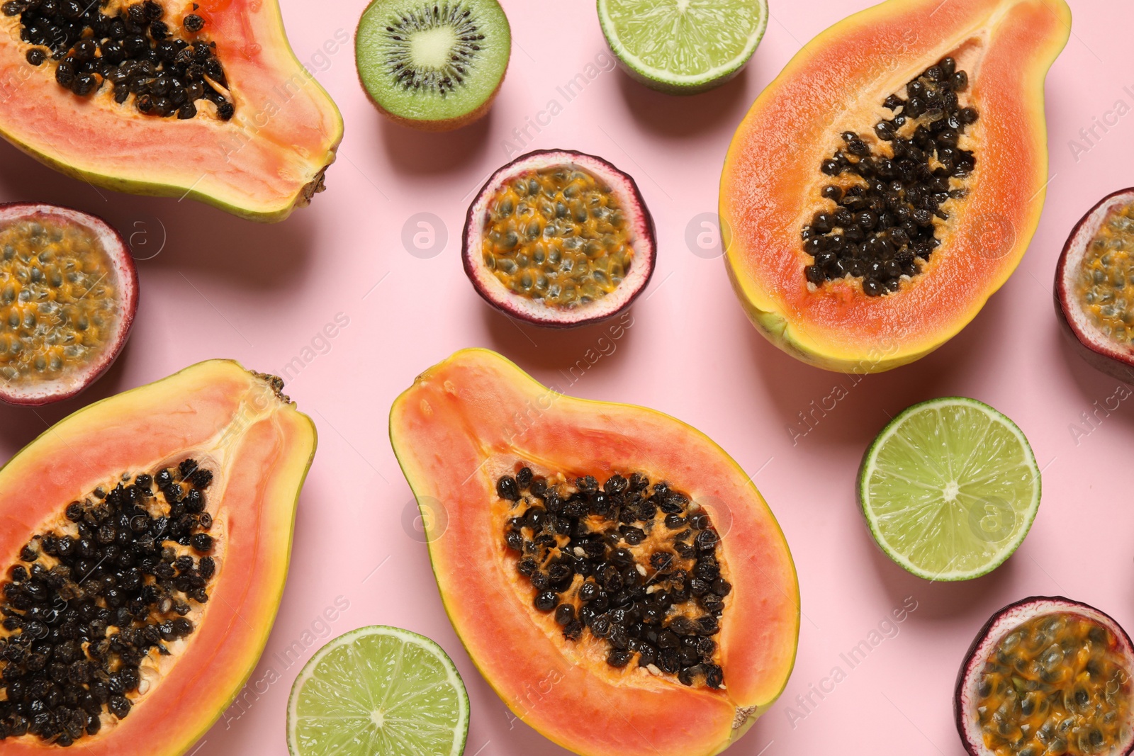 Photo of Fresh ripe papaya and other fruits on pink background, flat lay