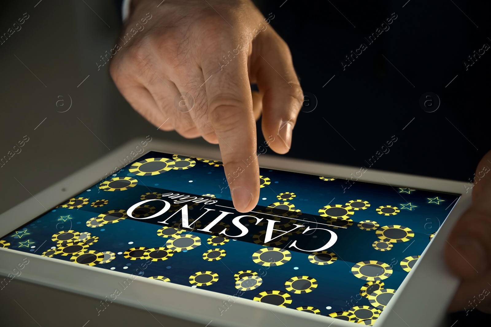 Image of Man playing poker on tablet, closeup. Casino online