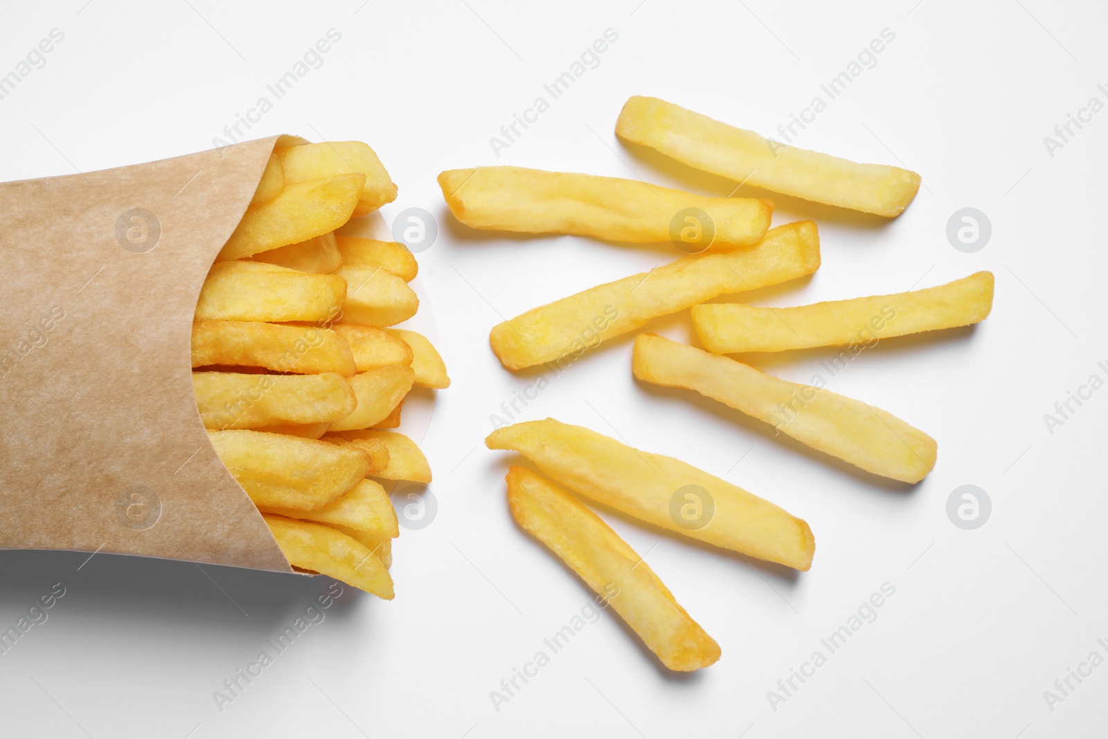 Photo of Paper cup with French fries on white table, flat lay