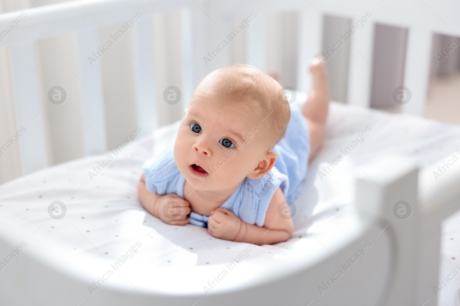 Photo of Cute little baby lying in crib at home