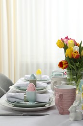 Photo of Easter celebration. Festive table setting with beautiful flowers and painted eggs