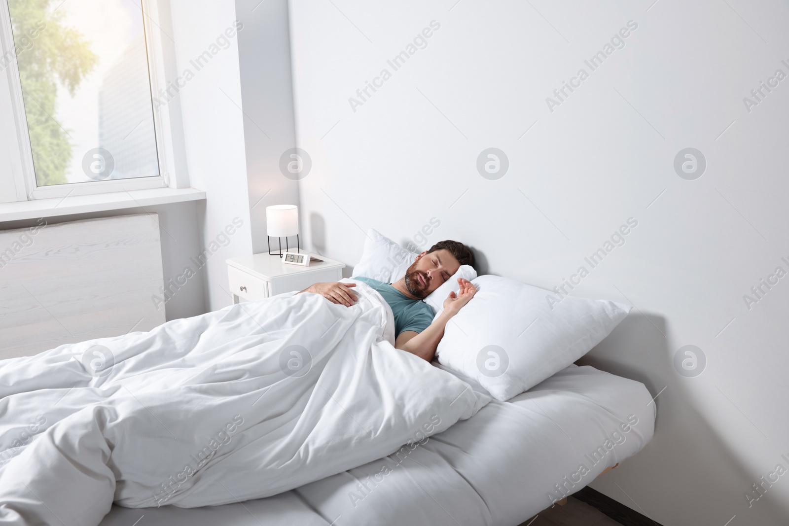 Photo of Man sleeping on comfortable pillows in bed at home