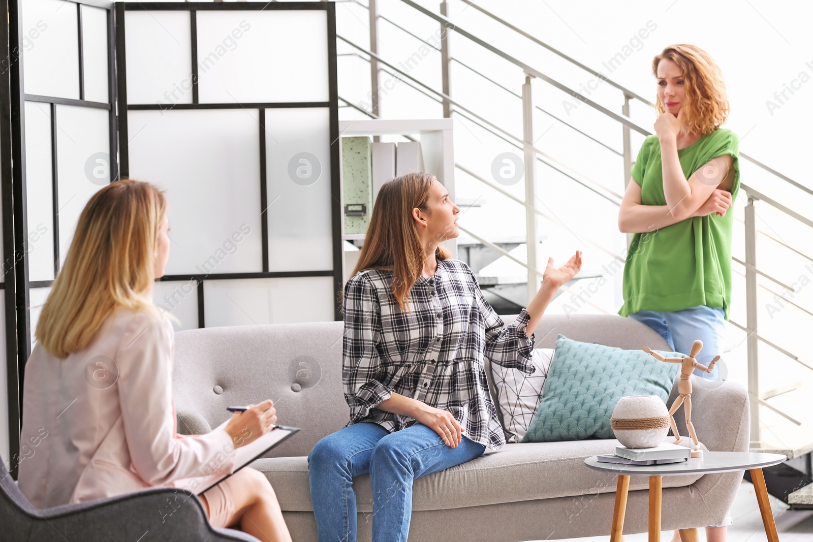 Photo of Young woman and her teenage daughter visiting child psychologist in office