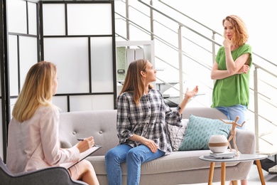 Young woman and her teenage daughter visiting child psychologist in office