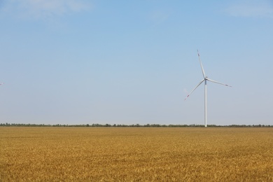Photo of Modern wind turbine in wheat field. Energy efficiency