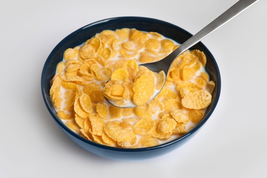 Photo of Eating cornflakes with milk on white background
