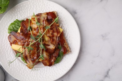 Photo of Tasty sandwich with bacon and microgreens on white marble table, top view. Space for text