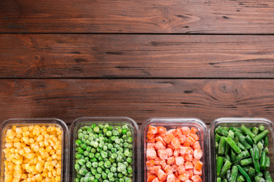 Photo of Different frozen vegetables on wooden table, flat lay. Space for text