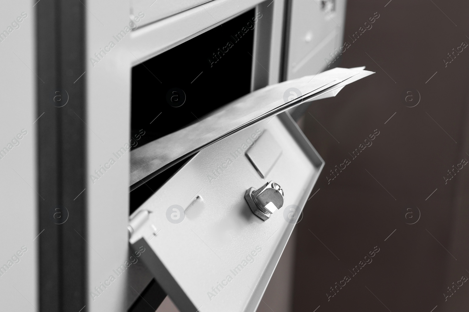 Photo of Open metal mailbox with envelopes indoors, closeup view