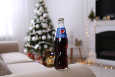 MYKOLAIV, UKRAINE - JANUARY 13, 2021: Glass bottle of Pepsi in room with Christmas tree