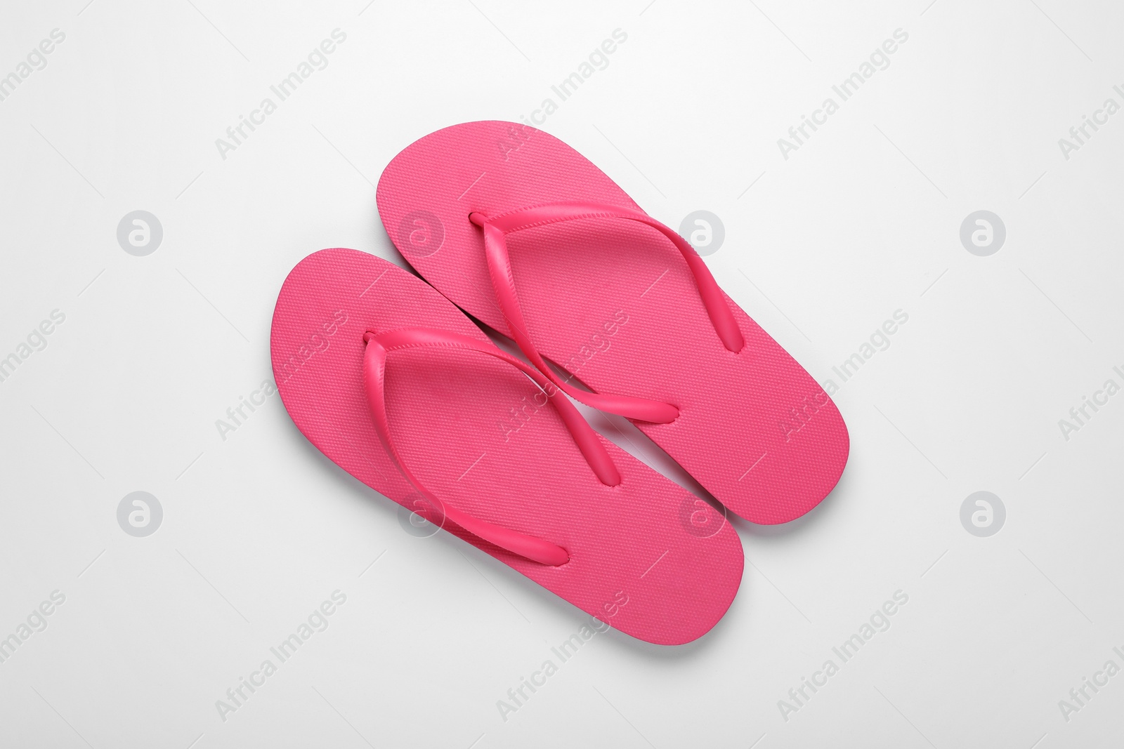 Photo of Stylish pink flip flops on white background, top view