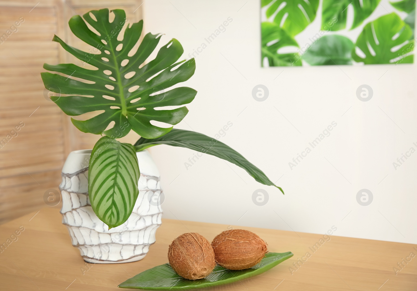 Photo of Vase with tropical leaves on table indoors. Interior design element