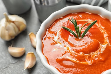 Photo of Bowl with fresh homemade tomato soup on table, closeup