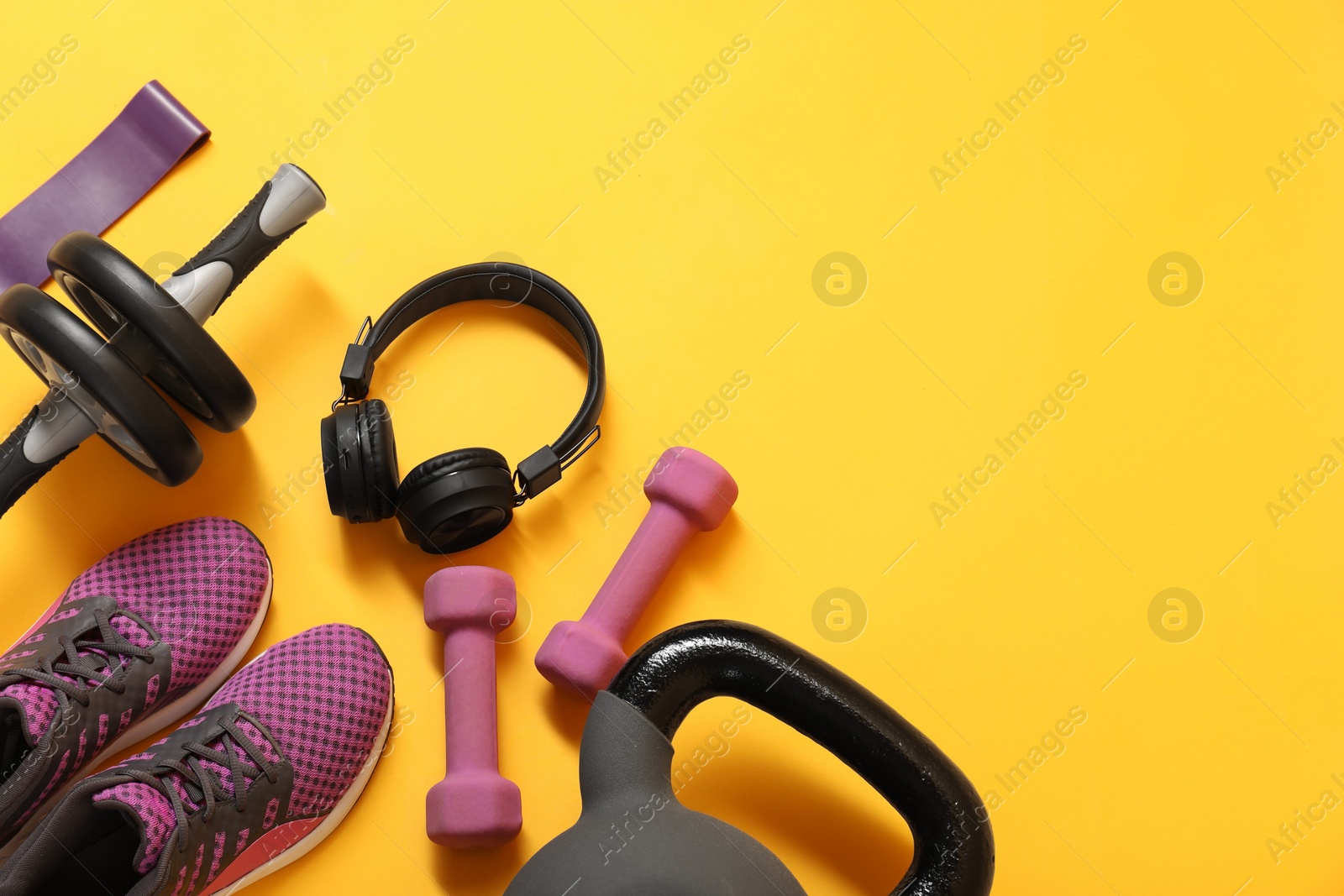 Photo of Different sports equipment on yellow background, flat lay. Space for text