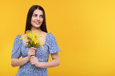 Happy young woman with beautiful bouquet on orange background. Space for text