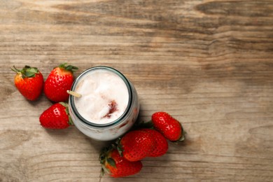 Photo of Tasty yoghurt with jam and strawberries on wooden table, top view. Space for text